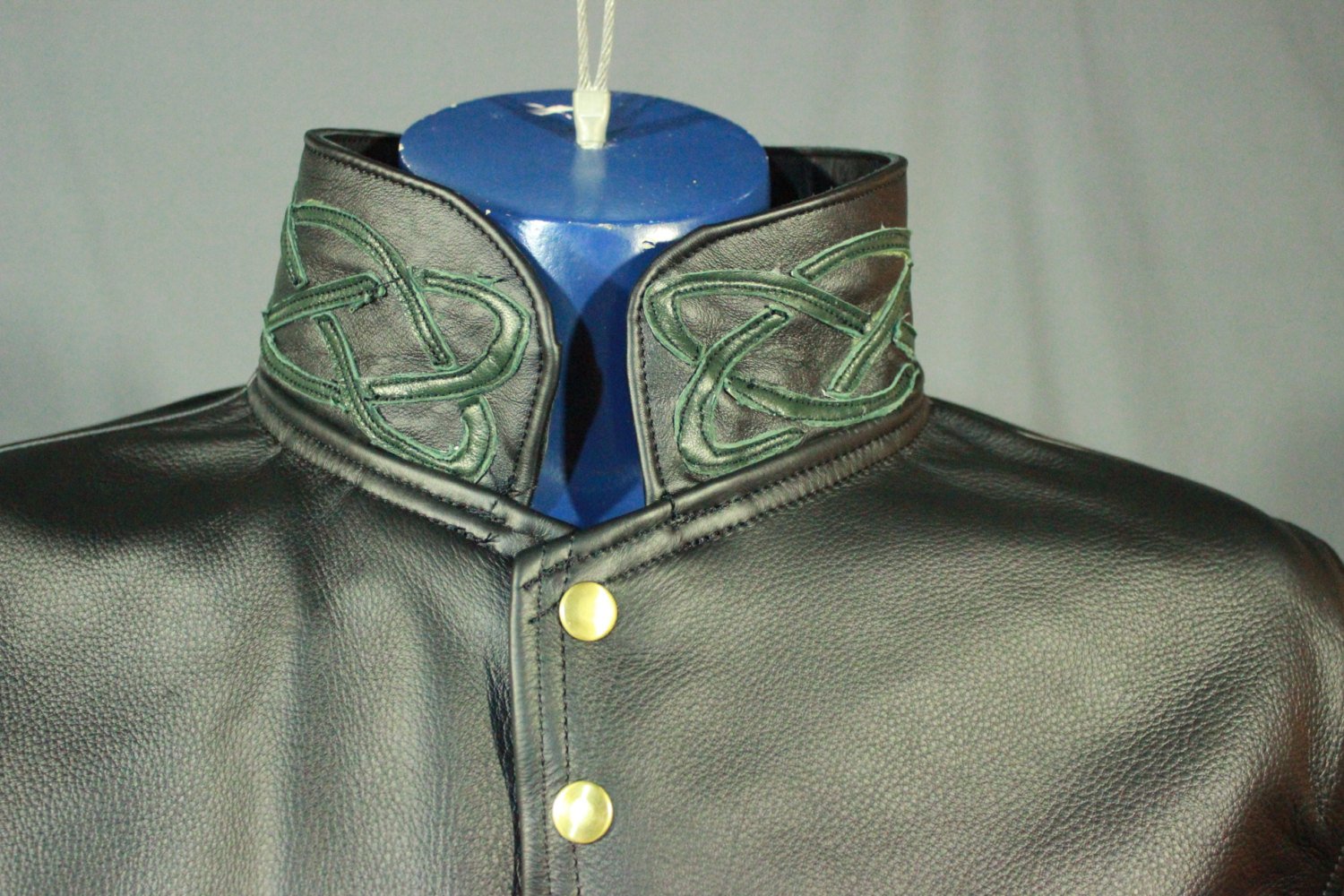 Manteau en cuir avec reflets celtiques en vert forêt.